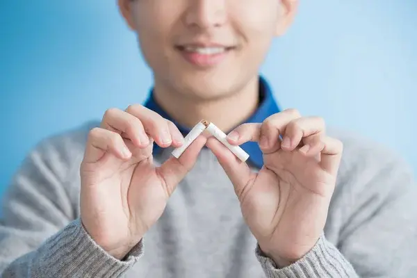fumador rompiendo un cigarro